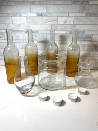 Glass Vases And Votive Bottles, 7 Vessels, 4 Votives.