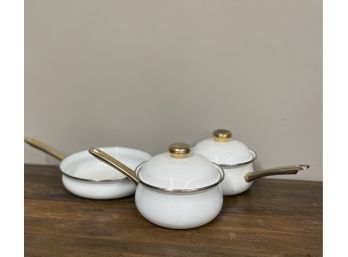 William Sonoma White Enamel Cookware Set With Gold Accents.