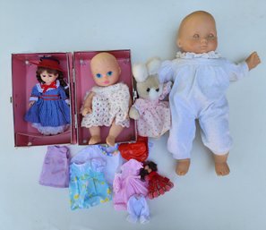 Assortment Of Dolls And Doll Clothing With Storage Box