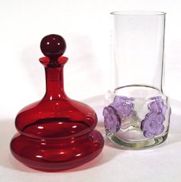 TWO DECORATIVE GLASS OBJECTS, INCLUDING A JONATHAN ADLER DECANTER AND GLASS VASE WITH APPLIED FLOWERS