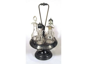 ANTIQUE SILVERPLATE AND GLASS FIVE-BOTTLE CASTOR SET IN THE AESTHETIC TASTE, CIRCA 1880s