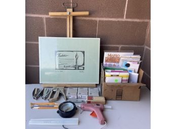 Assorted Lot Of Arts And Crafts Supplies Including Easel. Brand New Notepad, Staplers, Glue Gun, And More
