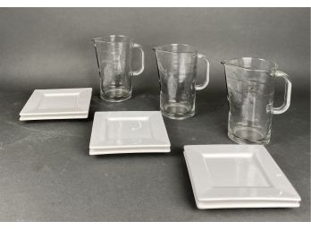 Three Glass Pitchers And Six White Square Ceramic Dishes