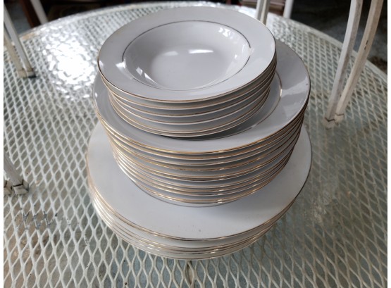 STACK OF WHITE GOLD RIMMED DISHES