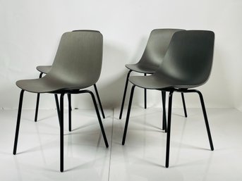 Four Modern Chairs With Molded Seats And Black Metal Frames