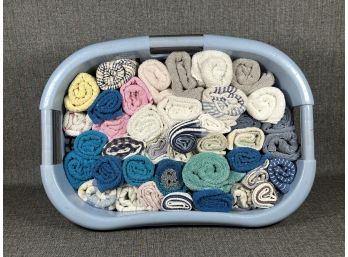 A Rubbermaid Laundry Basket Full Of Rolled Hand Towels