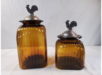 Two Amber Glass Canisters With Pewter Look Rooster Lids