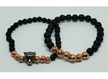 Pair Of Stretch Bracelets Made Of Black Lava Beads With Rose Tone Beads & Tiger Charm