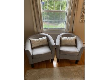 Pair Of Gray Upholstered Barrel Chairs With Striped Accent Pillows