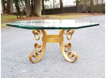 A Glass Top Coffee Table On Wrought Iron Base