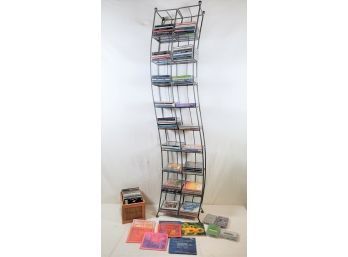 Contemporary Curved Grey Wire Rack CD Tower And Assortment Of CDs And Cassettes In Assorted Genres