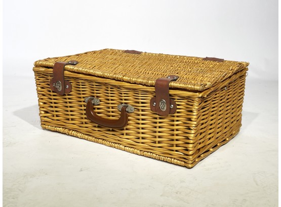 A Picnic Basket With Assorted Accessories Inside