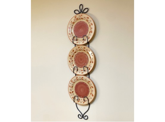 A Wrought Iron Plate Rack And Three Glazed Ceramic Plates