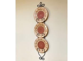 A Wrought Iron Plate Rack And Three Glazed Ceramic Plates
