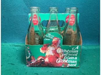 Six Pack Of Christmas Coca-Cola Bottles. Bottoms Marked Sandwich (2), Mitchell, Alexandria, Springfield.