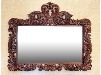 A Large Ornately Carved Wood Framed Beveled Mirror