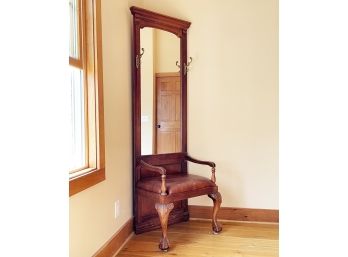 A Carved Hardwood Mirrored Hall Tree With Brass Hardware And A Leather Seat