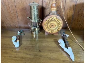 A BRASS MINORS SAFETY LAMP, TWO DECORATIVE PIPES AND A CARVED WOODEN FLASK 10' AND SMALLER