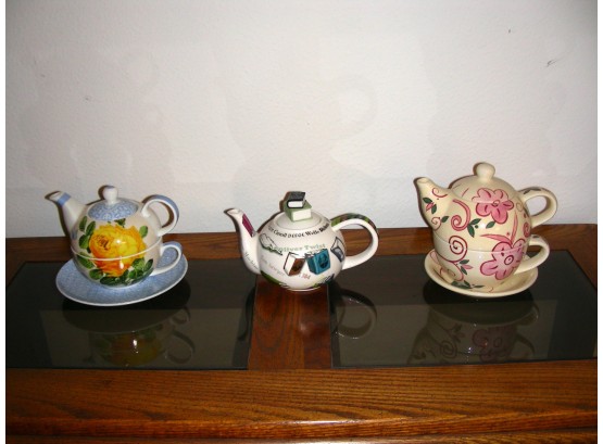 Three Teapots, 2 With Stacking Cups And Saucers Under The Teapots