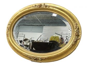 A Large Oval Mirror In Gilt Frame