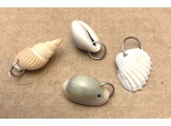 FOUR DIFFERENT SHELL PENDANTS