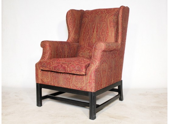 An Upholstered Wingback Chair In Paisley Print