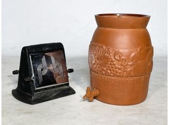 An Antique Toaster And Terra Cotta Cider Cask