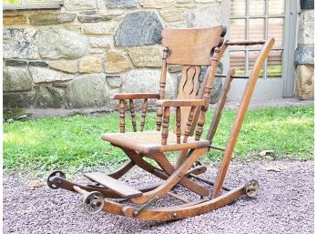 An Antique Oak And Cane Rocking Chair On Wheels