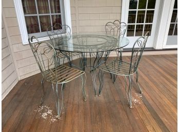 Round Glass Table With 4 Metal Chairs Located Upper Deck