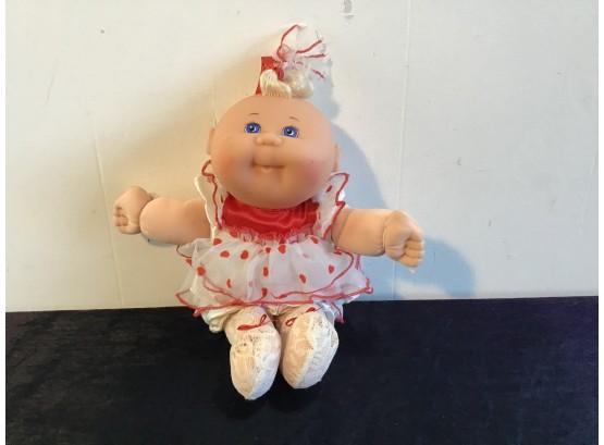 Blonde Cabbage Patch Doll With Blue Eyes And A White And Red Dress With Stockings