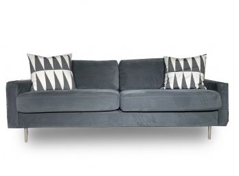 A Velvet Upholstered Modern Couch By CB2 With Marimekko Pillows