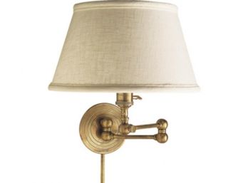 An Antique Brass Swing Arm Lamp With Linen Shade By Visual COmfort
