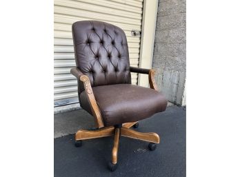 A Tufted Pleather Adjustable Desk Chair With Carved Arms