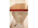 Vintage Wooden Table With A Curvaceous Wicker Base