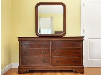 A Hard Wood Dresser With Beveled Mirror In Carved Wood Frame By Liberty Furniture