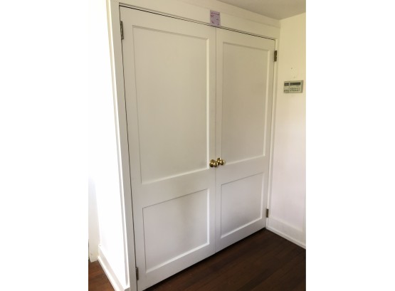 A Pair Of Wood, 2 Panel, Closet Doors With Magnetic Clasps, Located In Entry Hall