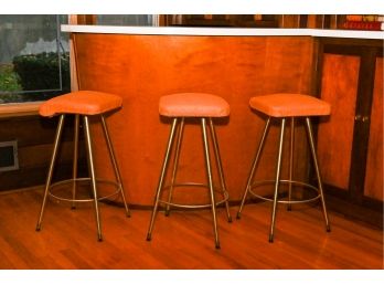 Set Of Three Metal Legged Bar-stools With Padded Orange Vinyl Seats.