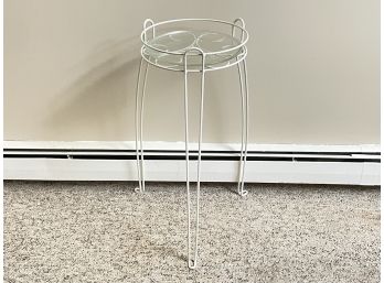 A Metal Plant Stand With Glass Insert