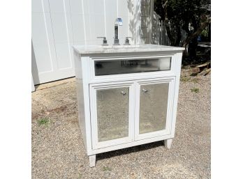 A Marble Top Vanity With Under Mount Sink And Mirrored Doors