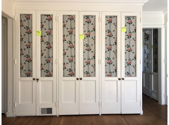 A Large Wardrobe System With French Styled Wire Mesh Panel Doors And Fabric