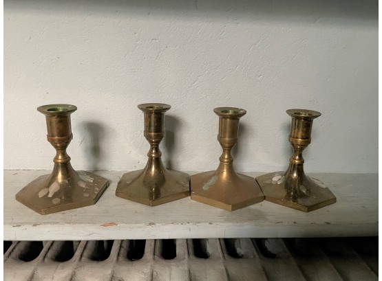 A Quartet Of Brass Candlesticks