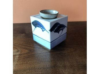 A Sake Bottle And Cup Which Serves As Lid