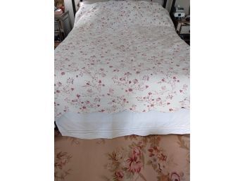Pretty White Quilted Bedspread With Dark Pinkish Red Flowers.