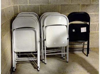 One Black Folding Chair And 8 White Folding Chairs