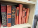Three Shelves Of Hard Bound Books In Shades Of Red