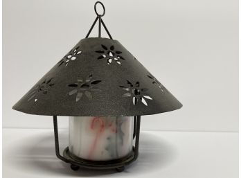 A Beautiful Metal Candle Holder With Flower Detail With A Holiday Candle
