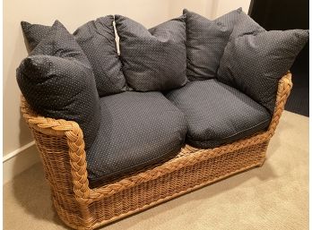 A Rattan Love Seat With Cushions