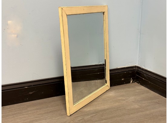 A Simple Beveled Wall Mirror In A Distressed Wood Frame