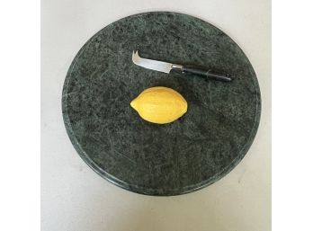 A Round Green Marble Cheese Board And A Cheese Knife