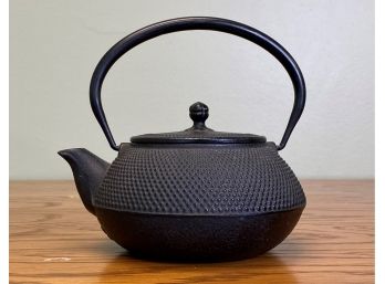 A Cast-Metal Tea Pot With Strainer Insert